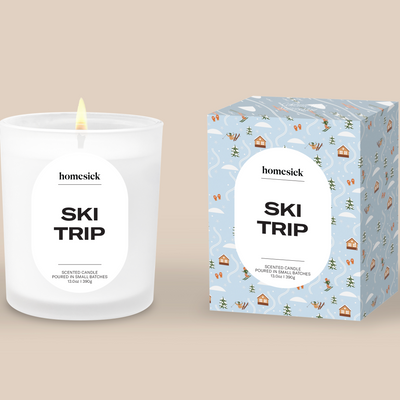 Homesick 'Ski Trip' candle and packaging on a beige background